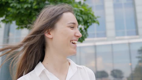 mujer riendo al aire libre mientras tiene una conversación divertida, primer plano estático de mano