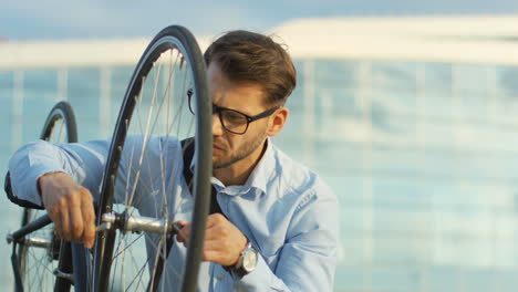 handsome man in business style riding a bicycle and stopping in front of the camera