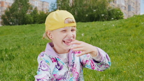 Blonde-Girl-In-A-Yellow-Cap-Playing-With-Dandelions-1