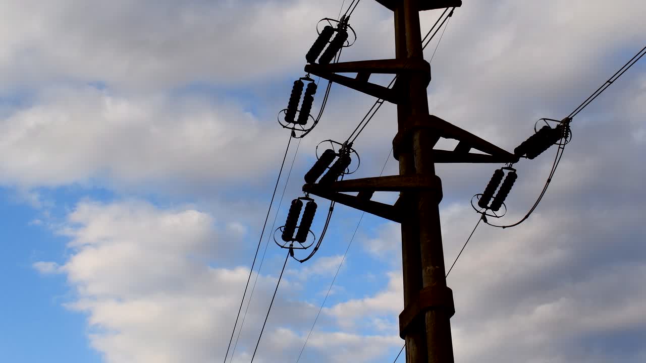 vista de ángulo bajo de líneas eléctricas de alta tensión contra las nubes al atardecer