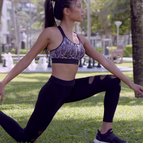 slim woman stretching leg in park