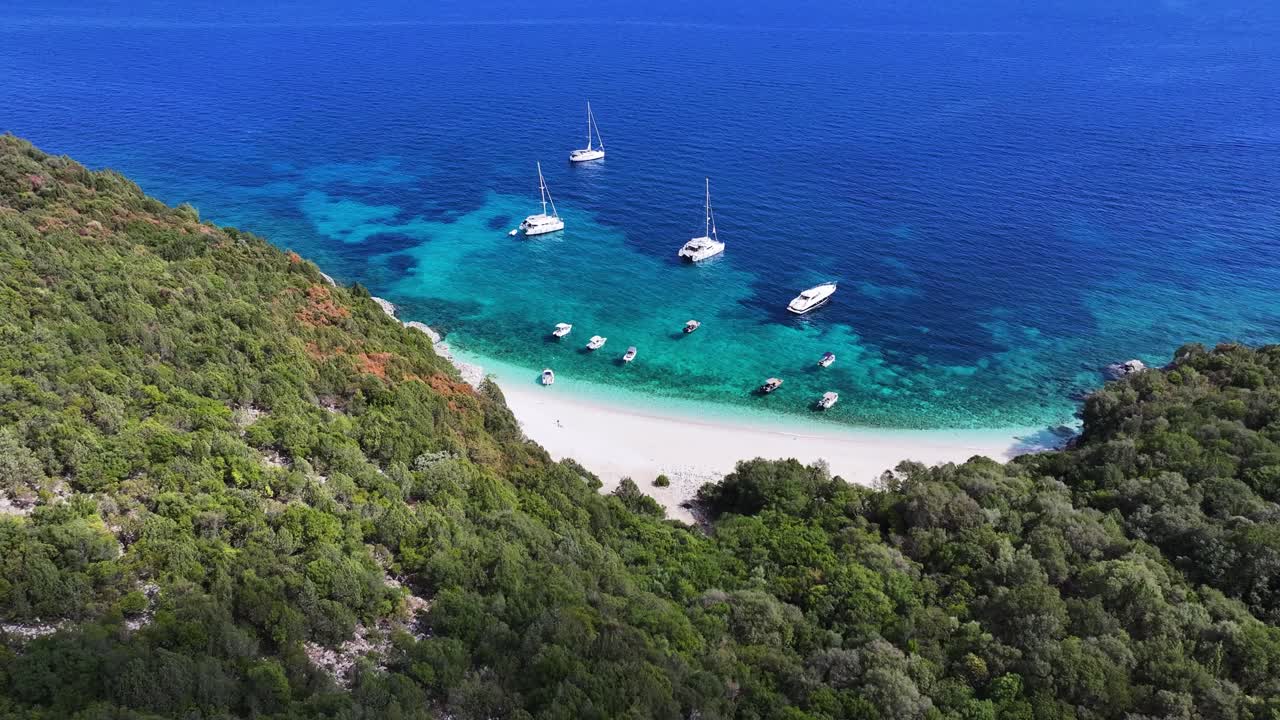 Koutsoupia beach in Sami, Zakynthos Greece with boats and ships anchored enjoying the gorgeous clear blue water on a sunny day AERIAL TRUCKING LEFT