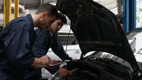 un guapo mecánico revisando un coche