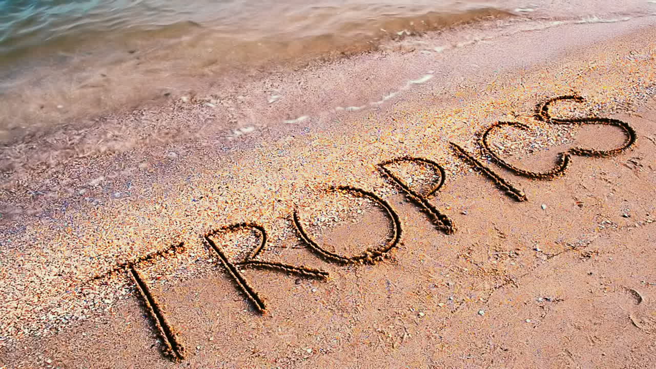 Inskription på sand i tropikerna. En inskription på stranden.
