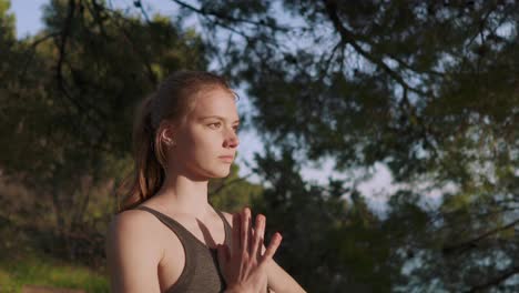 young woman doing sunrise morning yoga flow asana in outdoors forest