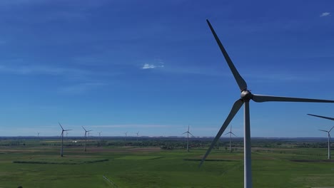 close shot of many wind turbines in the distance slowly spinning