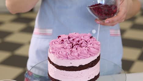 decorating a pink raspberry layered cake