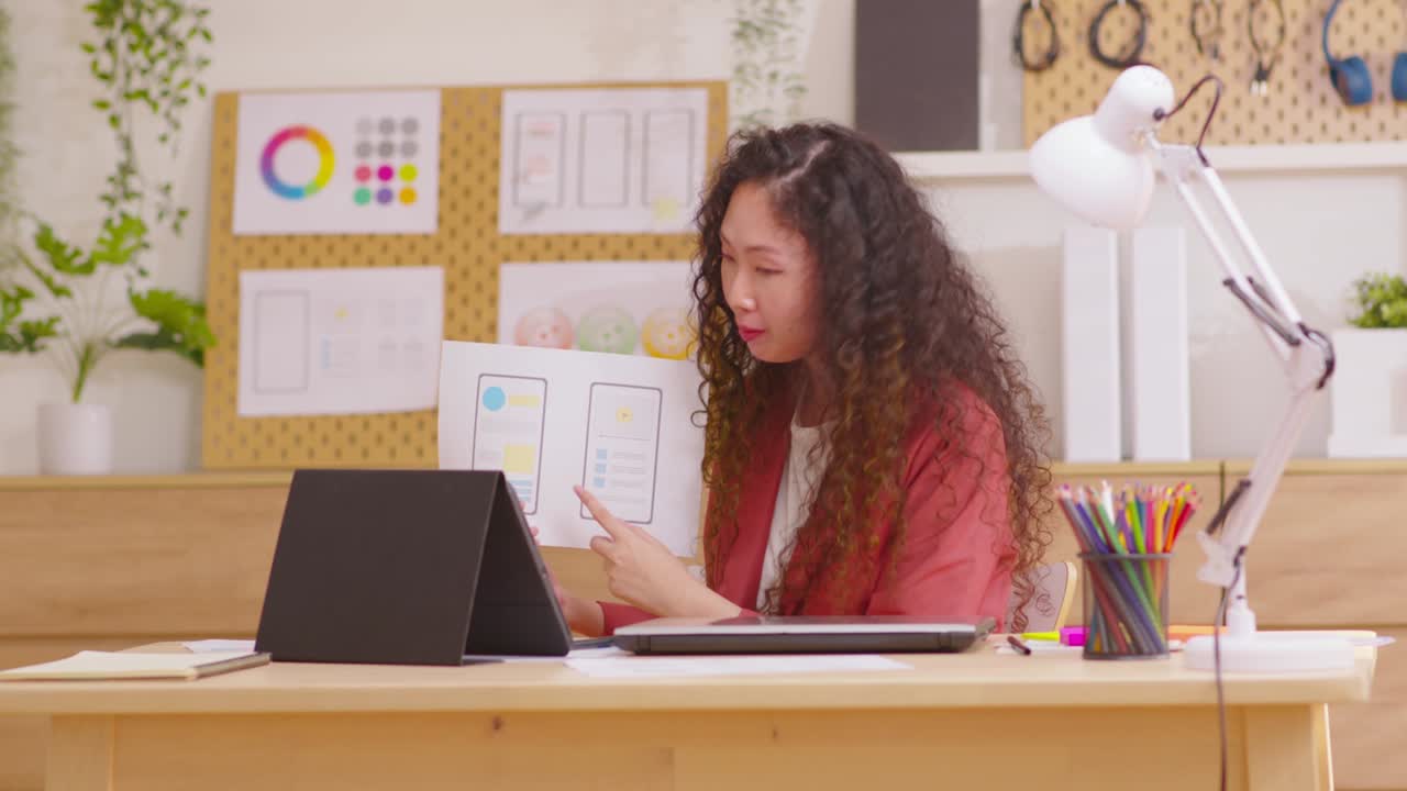 Asian businesswoman talking about sale report in video conference. Showing diagram charts using tablet online meeting in video call. Working from home, working remotely and self isolation at home.