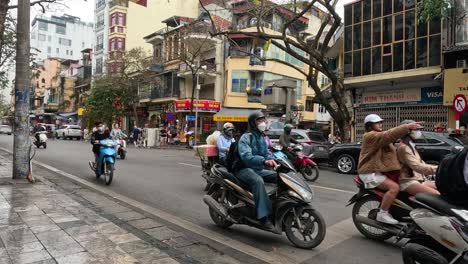 motorbikes and cars navigating a busy city junction