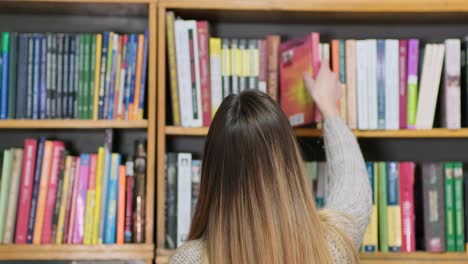 Blondine-Sucht-In-Einem-Bücherregal-Nach-Interessanter-Literatur