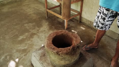 person smashing luwak coffee beans with stick in bali