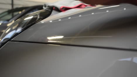 Close-up-slowmo-hand-applying-ceramic-coating-shiny-grey-car-hood-protective-work