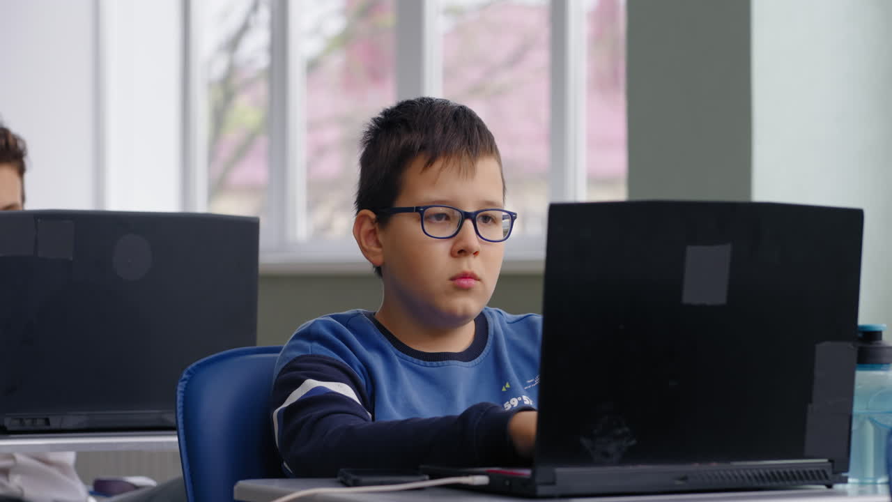 estudiante trabajando en una computadora portátil en el aula