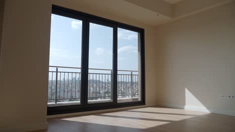 empty room with large window and city view