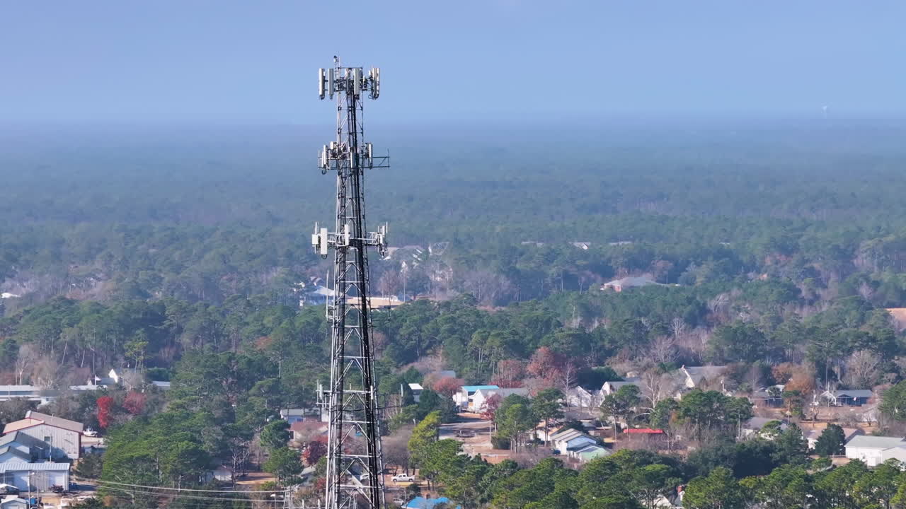 Ripresa aerea di un traliccio per telefonia mobile con città sullo sfondo