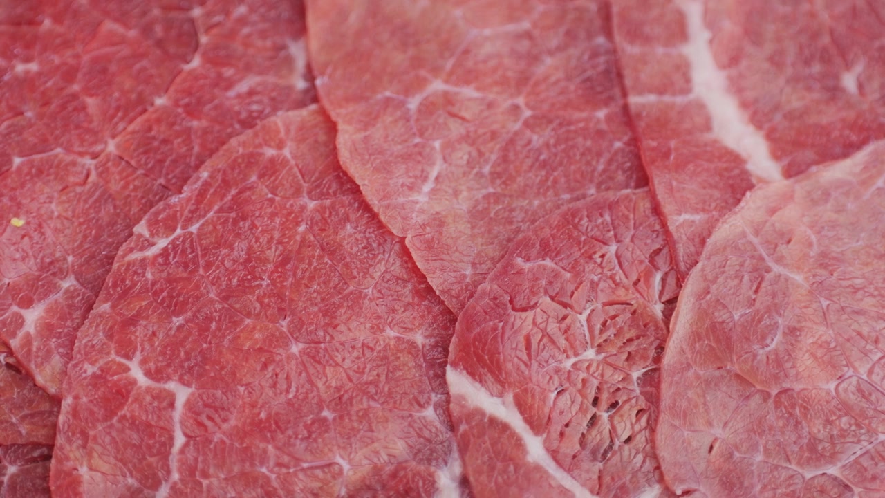霜降りの入った新鮮な薄切り生牛肉のクローズアップ