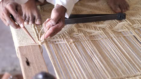 artisan weaving to make charpai, a traditional woven bed in sindh, pakistan