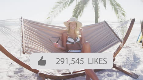 animation of speech bubble with thumbs up icon and numbers over woman in deckchair on beach