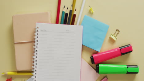 vídeo de un cuaderno con espacio para copiar y equipos escolares sobre fondo amarillo