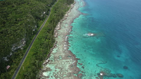 aerial view of a coral reefs and clear blue waters on the coast of the loyalty islands - reverse, drone shot