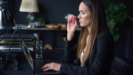 Businesswoman-working-on-laptop-in-office.-Woman-looking-at-graphs-on-screen