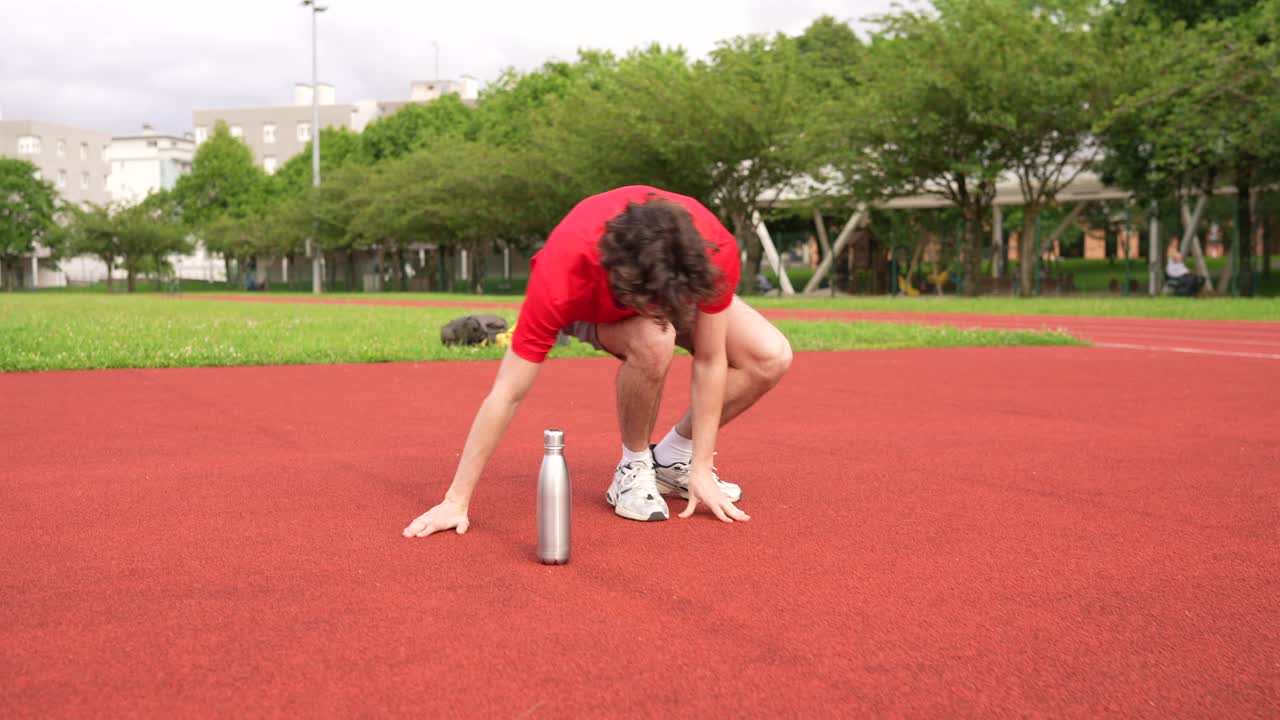 Man Stretching on a Running Track