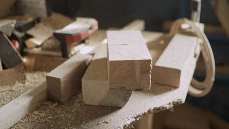 wood blanks and wood shavings on a workbench in a carpentry workshop in the rays of light