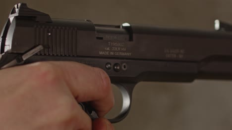Extreme-close-up-of-pistol-being-aimed-with-a-man's-finger-on-the-trigger