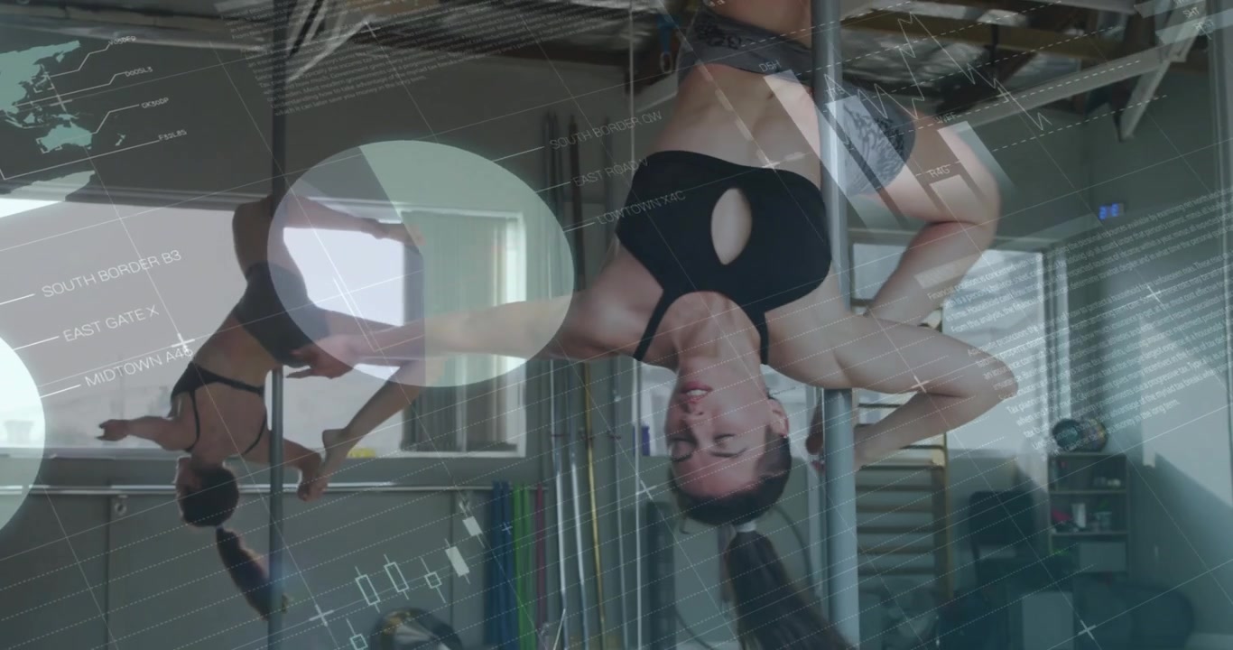 Woman gripping metal pole and lifting into inversion, displaying animated charts in fitness space