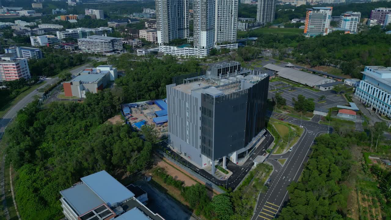 Tòa nhà trung tâm dữ liệu hiện đại đứng giữa cảnh quan xanh tươi, đại diện cho mạng lưới toàn cầu, dữ liệu lớn và cơ sở hạ tầng công nghệ điện toán đám mây. Góc nhìn tuyệt đẹp từ flycam bay lên cao.