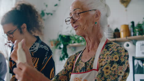 elderly woman stretching homemade dough as cooking with grandchildren
