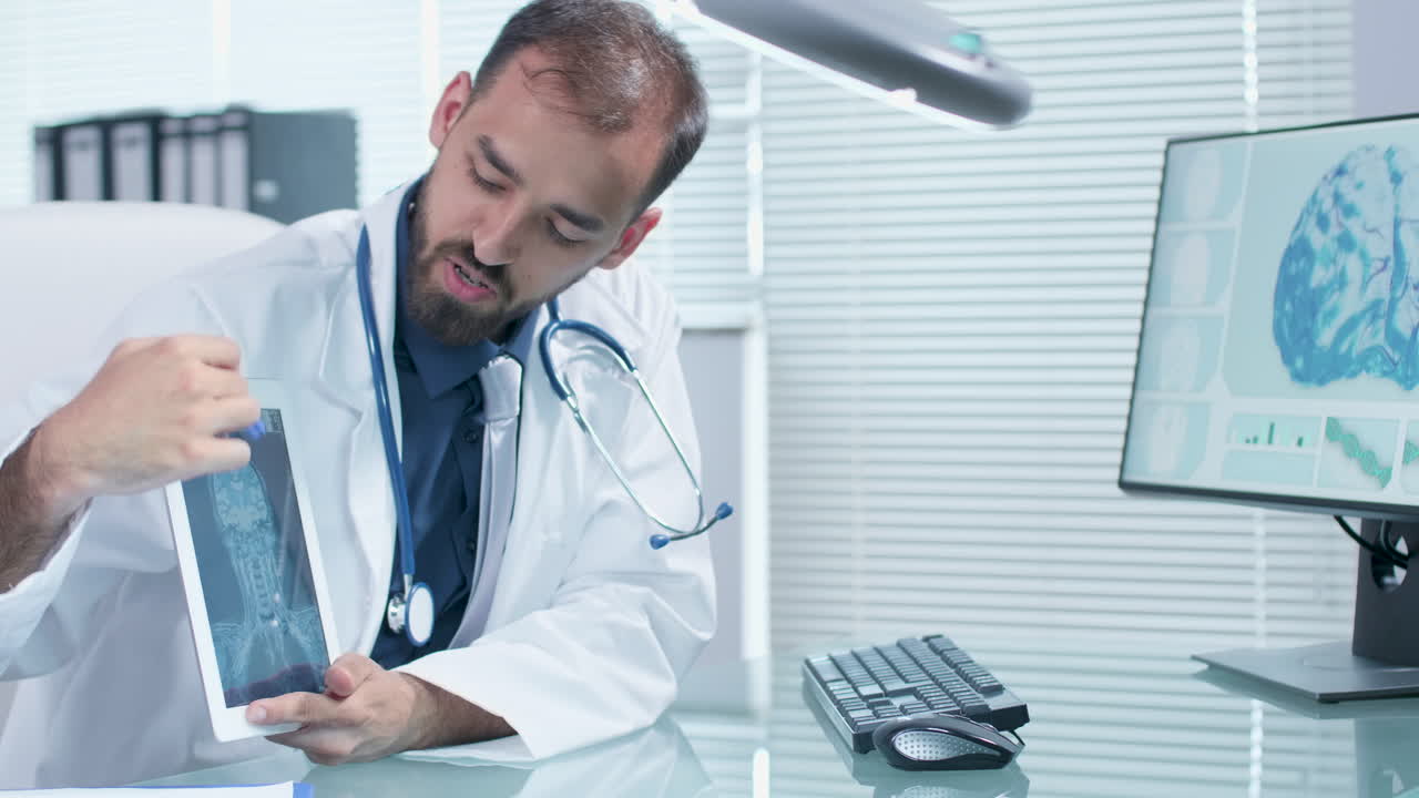 Doctor analyzing brain scan on tablet and computer