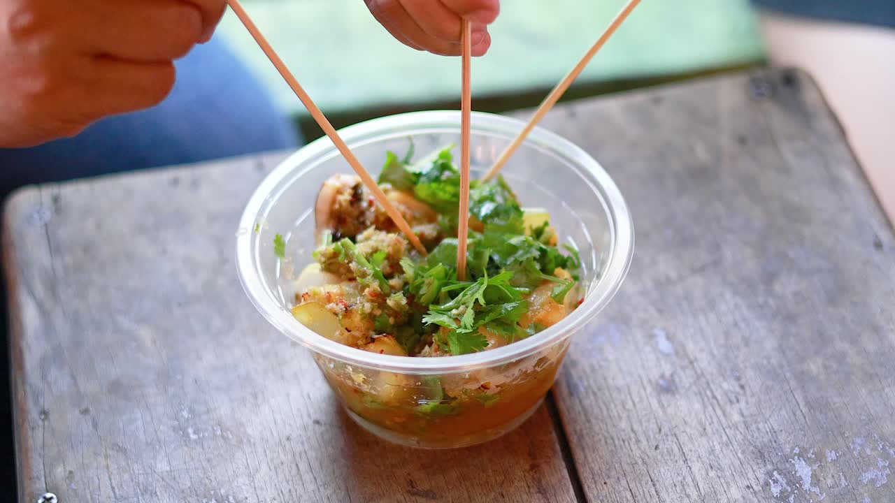 비는 시장 에서 그릴 된 오징어를 즐기고 있다