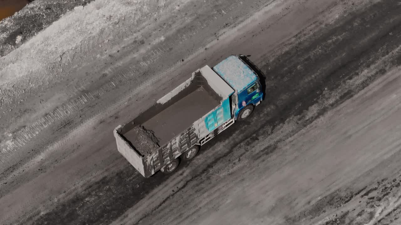minería de carbón - vista aérea de un camión volquete cargado de barro conduciendo en el sitio de la mina