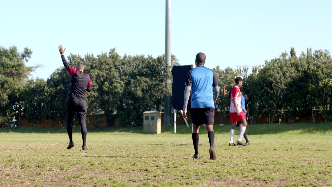 Playing soccer on field, boys in sports uniforms enjoying outdoor activity
