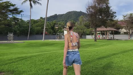 woman walking in a tropical park with exercise equipment