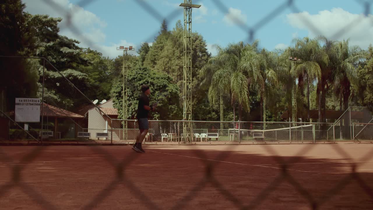 Man playing tennis on a clay court