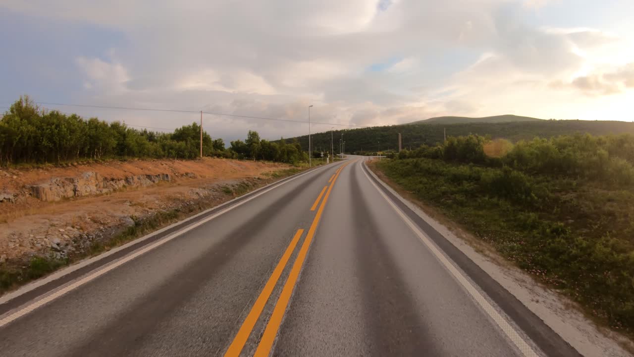 Conduciendo un coche por una carretera en Noruega al amanecer