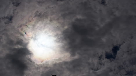 airplane silhouetted against dramatic clouds