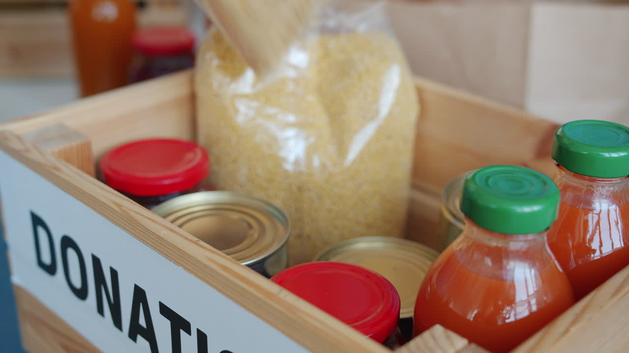 Hands donating food to a donation box