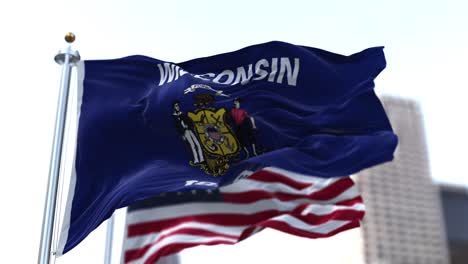 the flags of the wisconsin state and united states waving in the wind