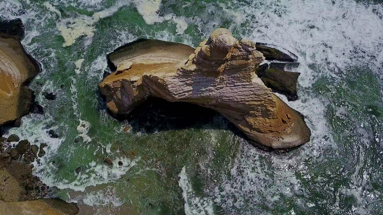 vista de arriba hacia abajo sobre la formación rocosa de la catedral con aves rodeadas por las olas del océano, perú