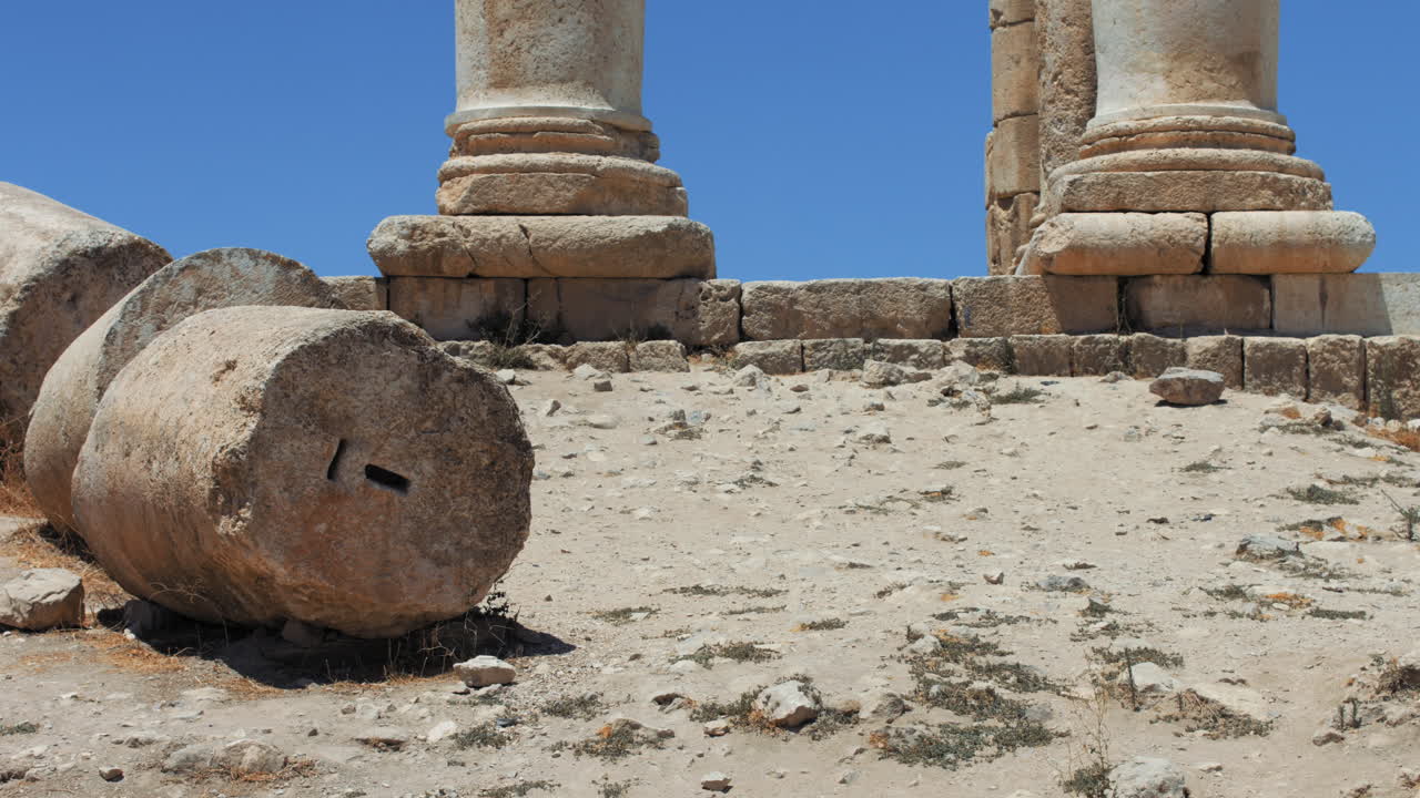 Ancient Fallen Roman Column tilt up to Temple of Hercules ruins at Jabal al-Qal'a, the Citadel of Amman, Jordan. 4K footage