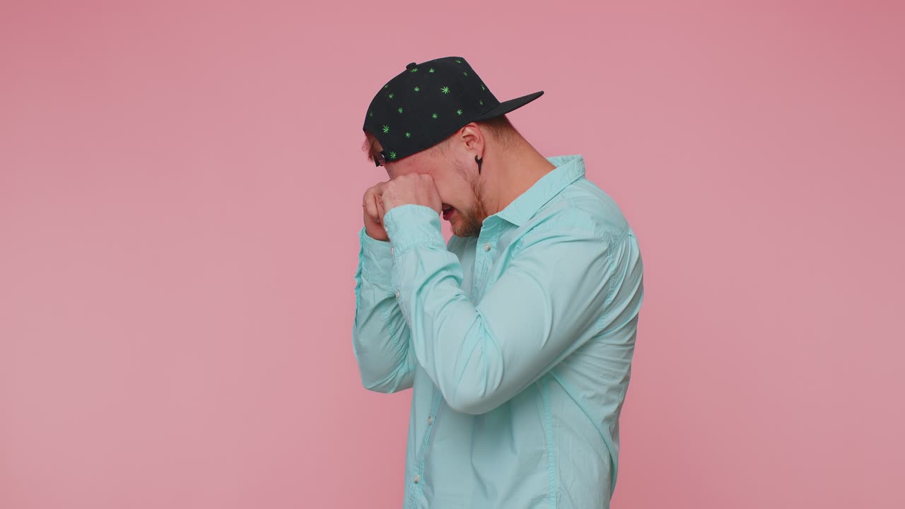 Upset disappointed man wipes tears and cries from despair being sad because of unfair things