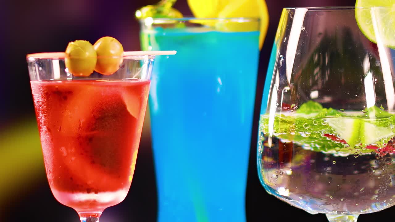 Three vibrant cocktails with garnishes, showcasing vivid colors and a lively atmosphere against a blurred background.