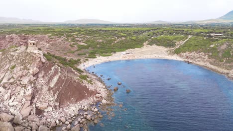 quiet beach in a small sea bay with a watchtower in sardinia aerial