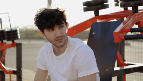man drinking water at outdoor gym
