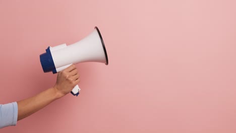 cropped image of a female hand holding a loudspeaker