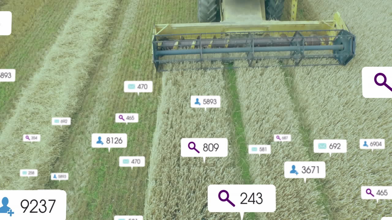 Combine harvester header harvesting wheat field, showing digital search, user and email icons