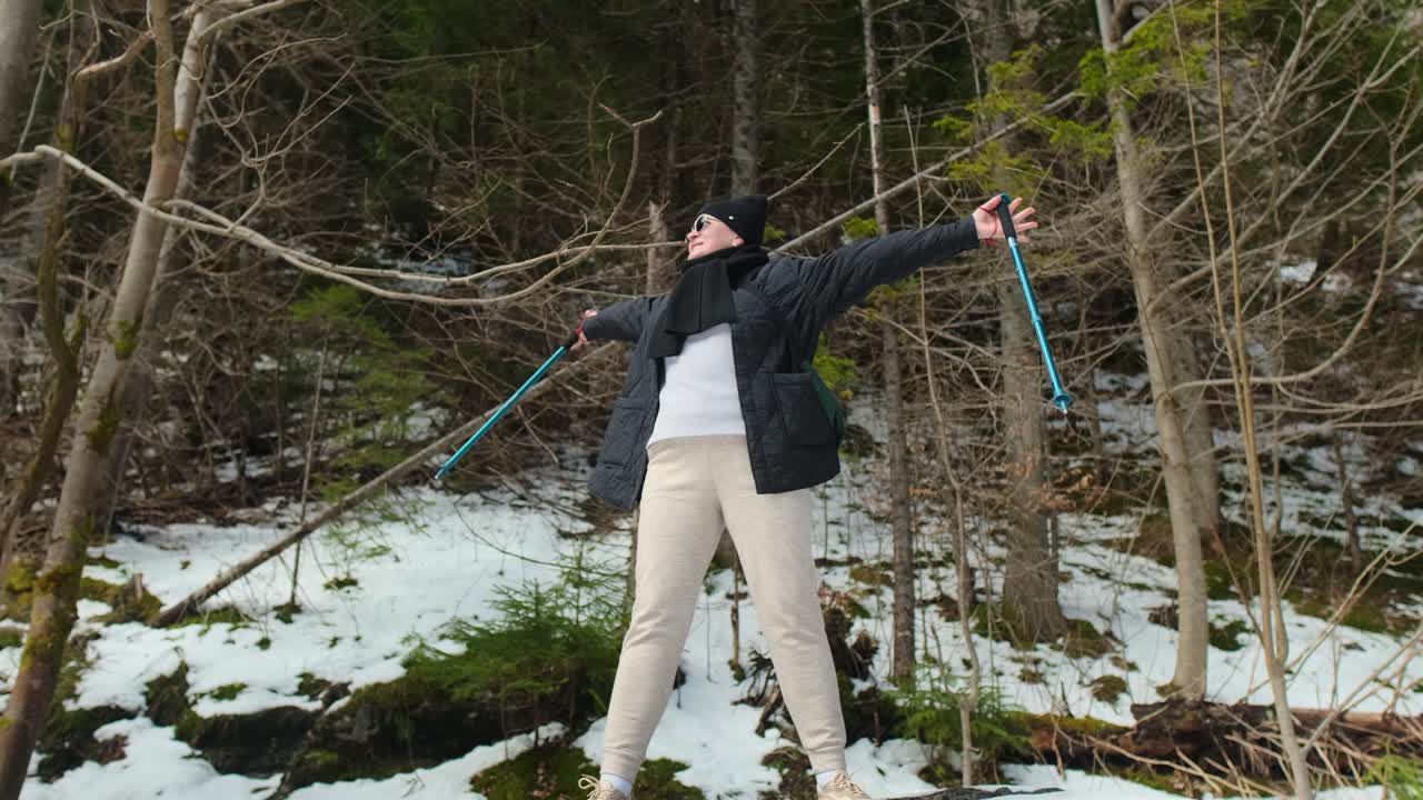 Woman Hiking in Snowy Forest with Nordic Walking Poles
